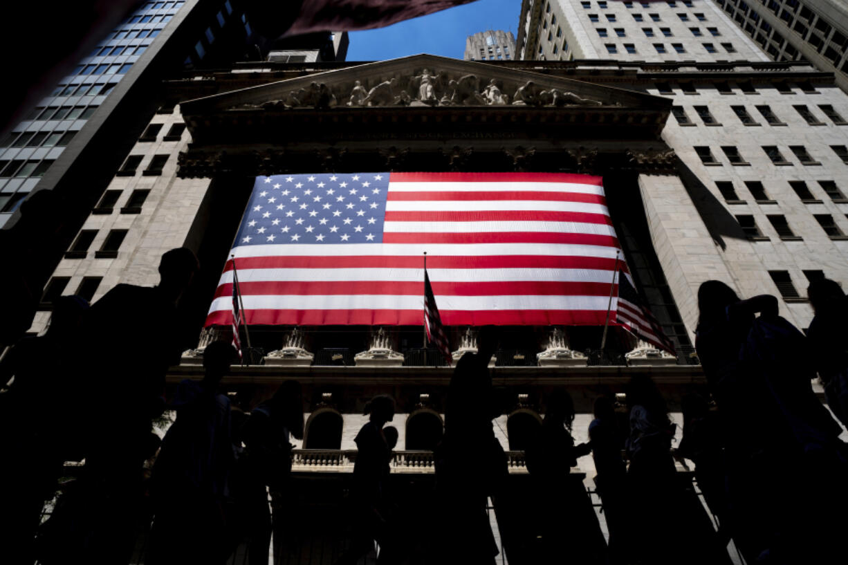 FILE - People walk past the New York Stock Exchange on Wednesday, June 29, 2022 in New York. Wall Street&rsquo;s best week of the year is getting even better Friday, Nov. 3, 2023, following a cooler-than-expected report on the job market.