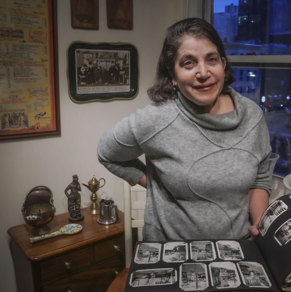 Anne D&rsquo;Innocenzio shows a family album surrounded by momentos from her childhood home Monday in New York. &ldquo;Clearing out Mom&rsquo;s house helped me fully appreciate her passion for a life full of family, art, books and travel,&rdquo; D&rsquo;Innocenzio said.