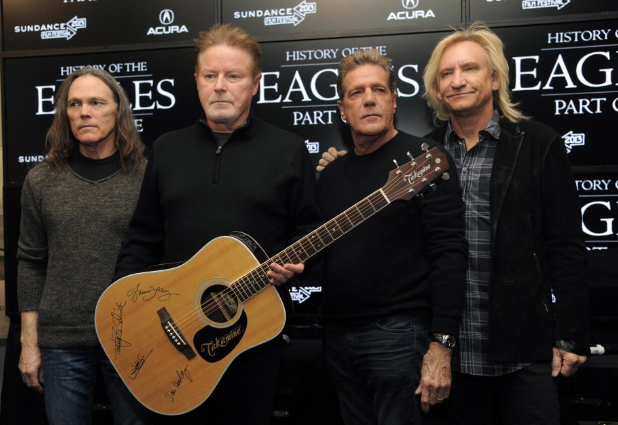 FILE - Members of The Eagles, from left, Timothy B. Schmit, Don Henley, Glenn Frey and Joe Walsh pose with an autographed guitar after a news conference at the Sundance Film Festival, Jan. 19, 2013, in Park City, Utah. On Wednesday, Feb.