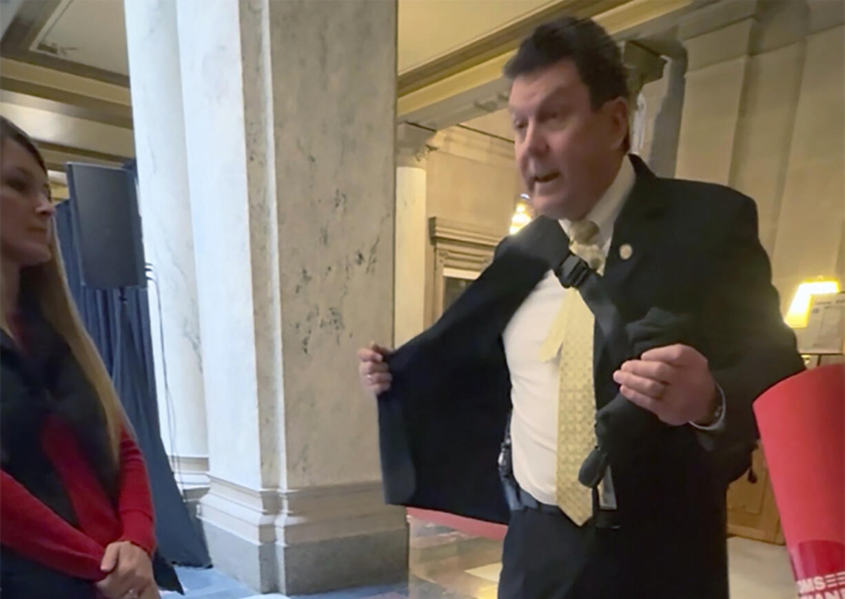 In this image taken from video, Indiana Rep. Jim Lucas, R-Seymour, flashes a holstered gun to students visiting the statehouse to talk to lawmakers about gun control, Tuesday, Jan. 30, 2024, in Indianapolis.
