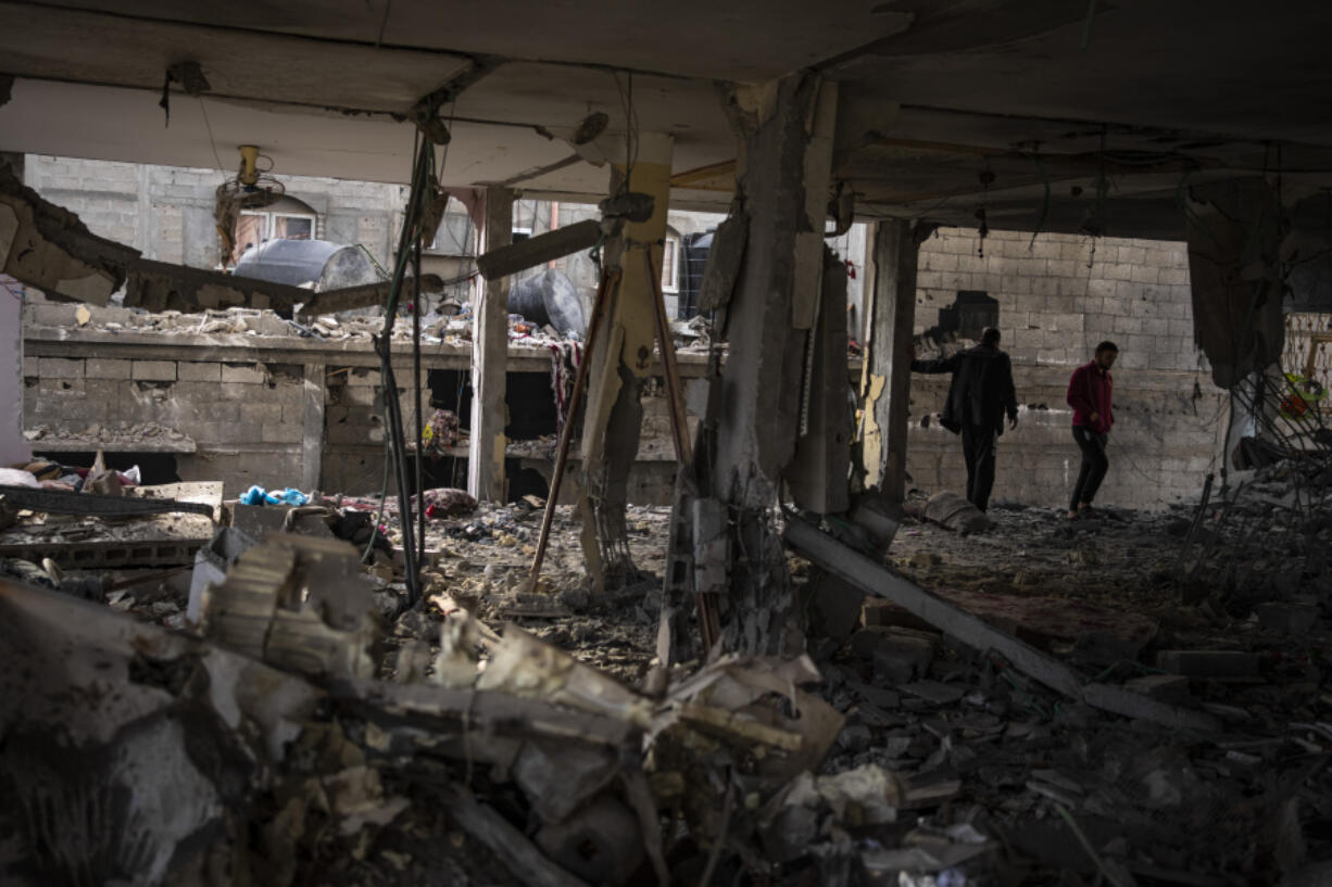 Palestinians look at the destruction after an Israeli airstrike in Rafah, Gaza SAtrip, Friday, Feb. 9, 2024.