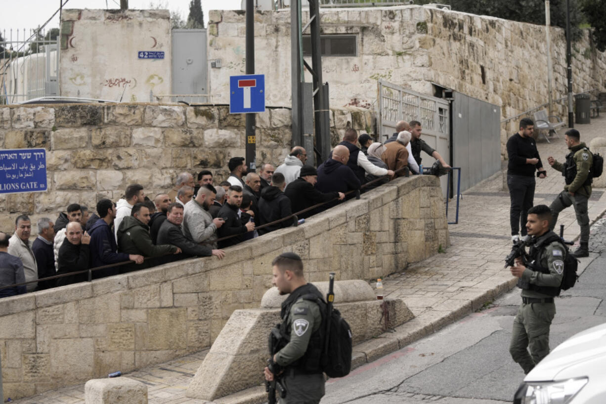 Israeli Border Police officers stand guard as Palestinian Muslim worshippers queue outside of the Al-Aqsa Mosque compound in Jerusalem&#039;s Old City ahead of Friday prayers, Friday, Feb. 23, 2024. Many other worshippers were not allowed in and prayed outside instead.