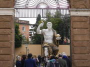 Visitors admire a massive replica of the statue Roman Emperor Constantine commissioned for himself after 312 AD that was built using 3D technology from scans of the nine giant original marble body parts that remain, as it was unveiled Tuesday in Rome.