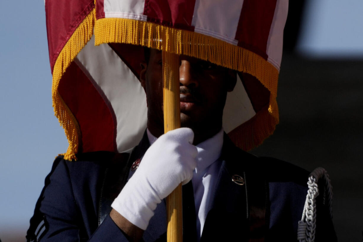 A US Airforce soldier holds the Stars and Stripes flag during a ceremony at the Sicily-Rome American Cemetery to commemorate the 80th Anniversary of the landing of allied forces on the shores of Anzio and Nettuno, in Nettuno, central Italy, Wednesday, Jan. 24, 2024.
