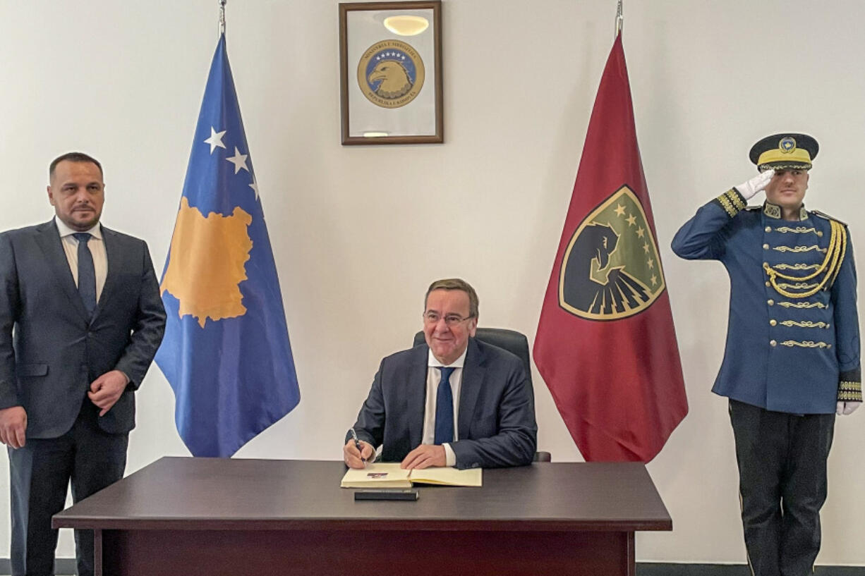 German Defense Minister Boris Pistorius, signs a friendship book as Kosovo&rsquo;s Defense Minister Ejup Maqedonci stands by, in Pristina, Kosovo, Monday, Feb. 5, 2024.