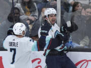 Seattle Kraken center Matty Beniers, right, celebrates with right wing Jordan Eberle after scoring against the Boston Bruins during the third period of an NHL hockey game Thursday, Feb. 15, 2024, in Boston.