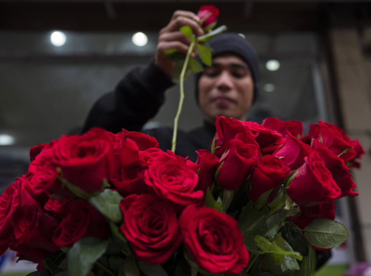 A flower vendor arranges roses for sale during Valentine&rsquo;s Day in Lalitpur, Nepal, Wednesday, Feb. 14, 2024.