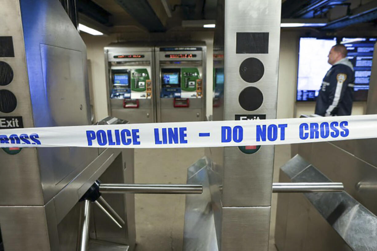 New York Police walk through the Mount Eden subway station while investigating a shooting, Monday, Feb. 12, 2024, in the Bronx borough of New York. Several people were shot Monday at the New York City subway station, police said.
