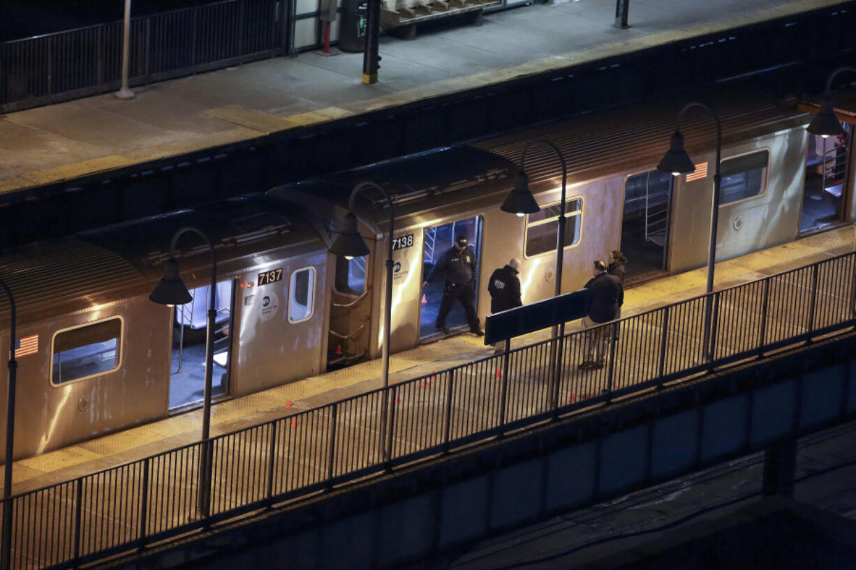 New York Police walk through the Mount Eden subway station while investigating a shooting on the platform, Monday, Feb. 12, 2024, in the Bronx borough of New York.