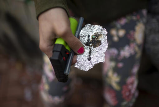 FILE - A person holds drug paraphernalia near the Washington Center building on SW Washington St. in downtown Portland, Ore. on April 4, 2023. A bipartisan group of Oregon lawmakers are working to boost funding for jails to provide medication used to treat opioid addiction. The move comes as the fentanyl crisis has pushed the Legislature to consider overhauling the state&rsquo;s pioneering drug decriminalization law by once again making it a crime to possess small amounts of drugs.