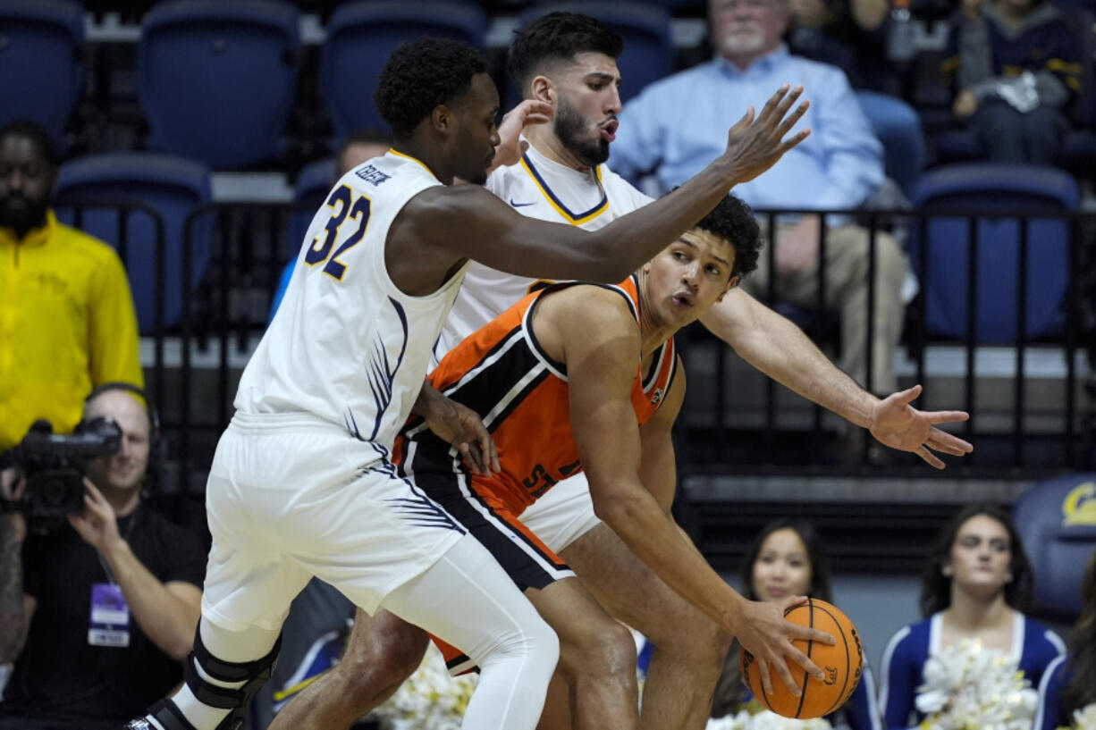 Oregon State forward Michael Rataj, center, looks for an open teammate while defended by California guard Jalen Celestine (32) and forward Fardaws Aimaq, rear, during the first half of an NCAA college basketball game Thursday, Feb. 22, 2024, in Berkeley, Calif. (AP Photo/Godofredo A.