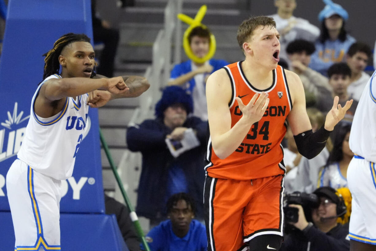 Oregon forward Tyler Bilodeau, right, reacts after being called for traveling as UCLA guard Dylan Andrews gestures during the second half of an NCAA college basketball game Thursday, Feb. 1, 2024, in Los Angeles. (AP Photo/Mark J.