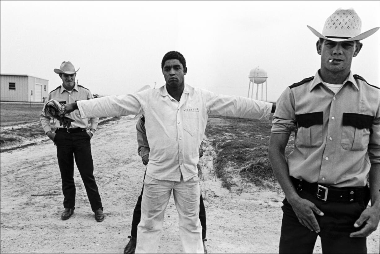 In this 1973 photo, three guards shake down and body search a prisoner and at the Cummins Unit of&rsquo; Arkansas Department of Corrections in Grady, Ark. The convict-leasing period, which officially ended in 1928, helped chart the path to America&rsquo;s modern-day prison-industrial complex. Incarceration was used not just for punishment or rehabilitation but for profit.