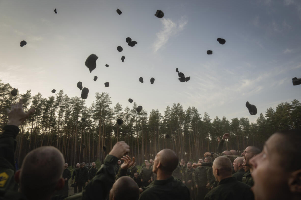 Newly recruited soldiers toss their hats as they celebrate the end of their training at a military base close to Kyiv, Ukraine, Monday, Sept. 25, 2023. As the third year of war begins, the most sensitive and urgent challenge pressing on Ukraine is whether it can muster enough new soldiers to repel &ndash; and eventually drive out &ndash; an enemy with far more fighters at its disposal.
