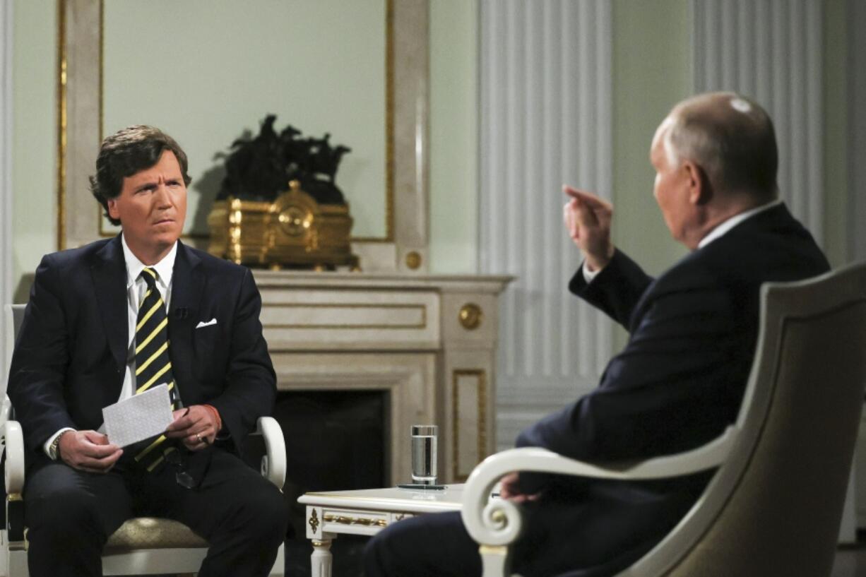 In this photo released by Sputnik news agency on Friday, Feb. 9, 2024, Russian President Vladimir Putin, right, gestures as he speaks during an interview with former Fox News host Tucker Carlson at the Kremlin in Moscow, Russia, Tuesday, Feb. 6, 2024.