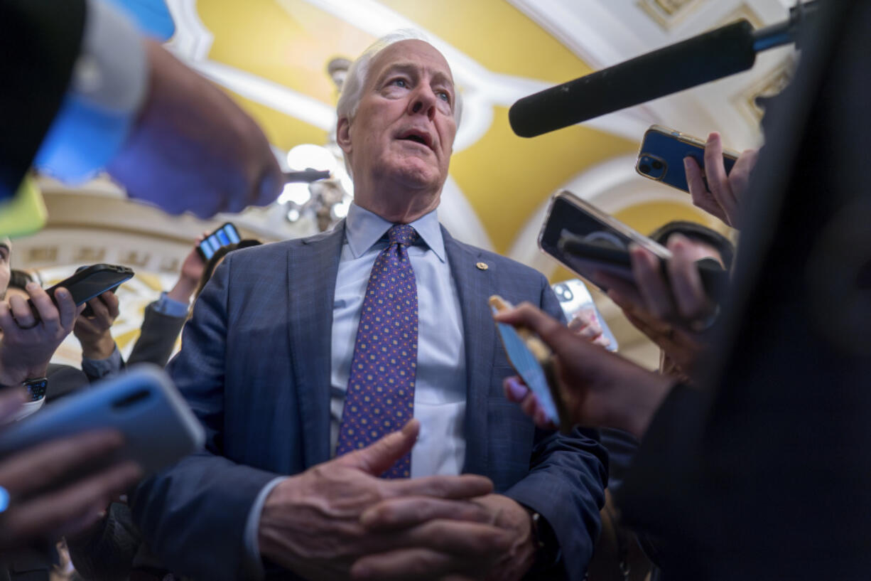 FILE - Sen. John Cornyn, R-Texas, is surrounded by reporters as he heads to the chamber at the Capitol in Washington, Feb. 7, 2024. (AP Photo/J.