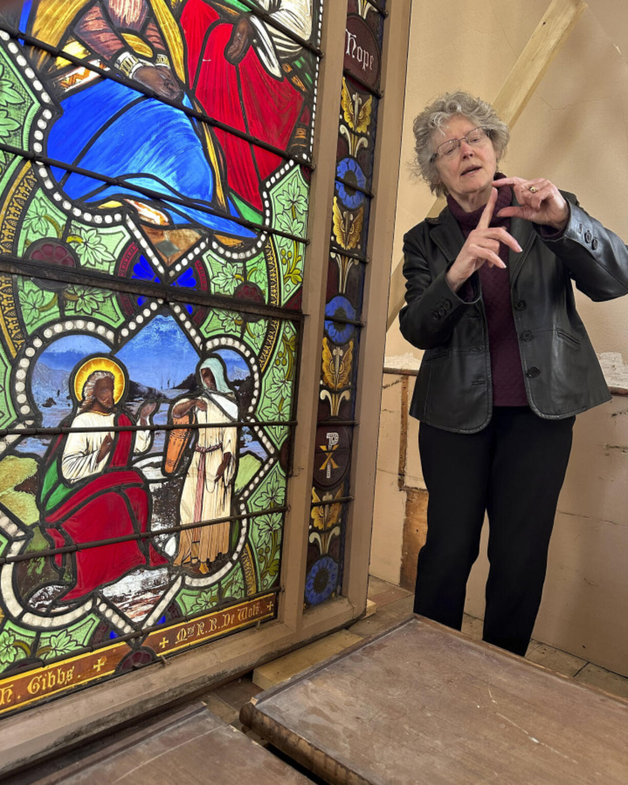 Holy Cross professor and stained-glass expert Virginia Raguin speaks to a group of middle school students May 1, 2023, while standing by a nearly 150-year-old stained-glass window that depicts Christ speaking to a Samaritan woman in a Warren, R.I., church.