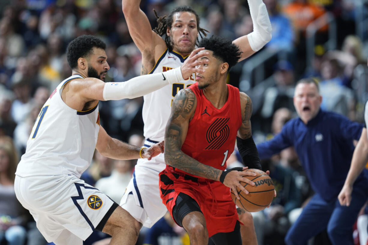 Portland Trail Blazers guard Anfernee Simons, front right, is trapped with the ball by Denver Nuggets guard Jamal Murray, left, and forward Aaron Gordon, back right, in the second half of an NBA basketball game Sunday, Feb. 4, 2024, in Denver.