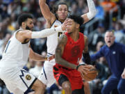 Portland Trail Blazers guard Anfernee Simons, front right, is trapped with the ball by Denver Nuggets guard Jamal Murray, left, and forward Aaron Gordon, back right, in the second half of an NBA basketball game Sunday, Feb. 4, 2024, in Denver.