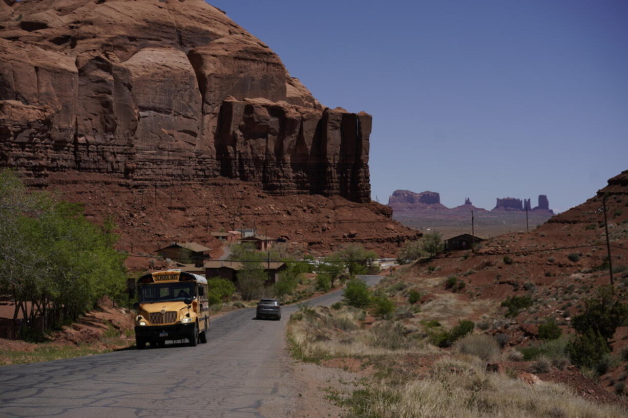 FILE - A school bus moves up Rock Door Canyon Rd., in Oljato-Monument Valley, Utah, on the Navajo reservation,  April 27, 2020. The U.S. Federal Energy Regulatory Commission has rejected several proposed hydropower projects on the largest Native American reservation in the U.S. The commission has also created a policy that essentially gives tribes veto power over such projects early on.
