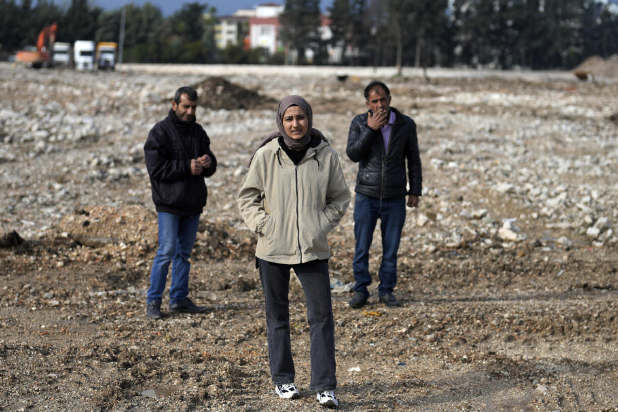 Sevda Kose, 22, center, stands on the ground where an eight-story apartment building that was home to her brother, his wife and their six-month old baby once stood in Antakya, southern Turkey, Thursday, Jan. 11, 2024. Kose&rsquo;s relatives are still missing a year after the powerful Feb. 6, 2023 earthquake struck, reducing homes to rubble.