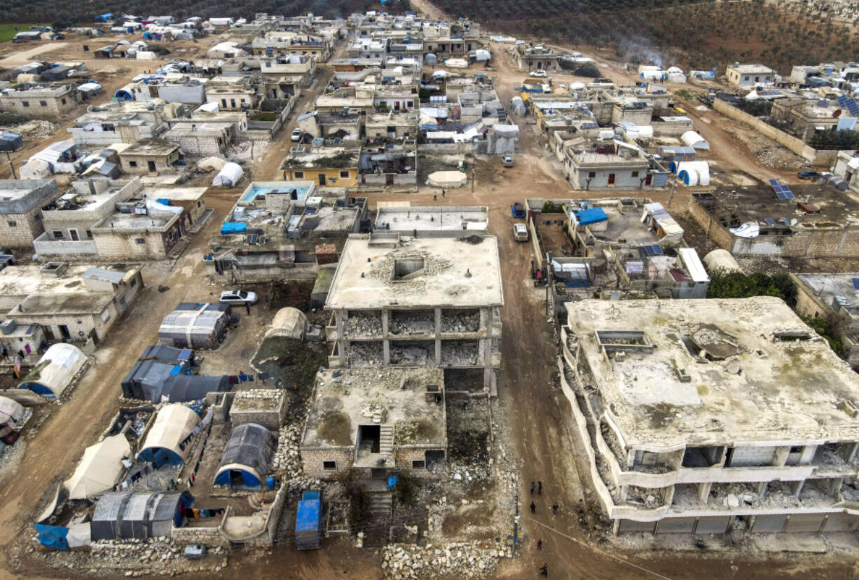 An aerial view shows tents used as shelters placed next to buildings that were destroyed in the February 2023 earthquake, in Idlib province, Syria, Thursday, Jan. 25, 2024. A year after the devastating 7.8 magnitude earthquake struck southern Turkey and northwestern Syria, a massive rebuilding effort is still trudging along. The quake caused widespread destruction and the loss of over 59,000 lives.