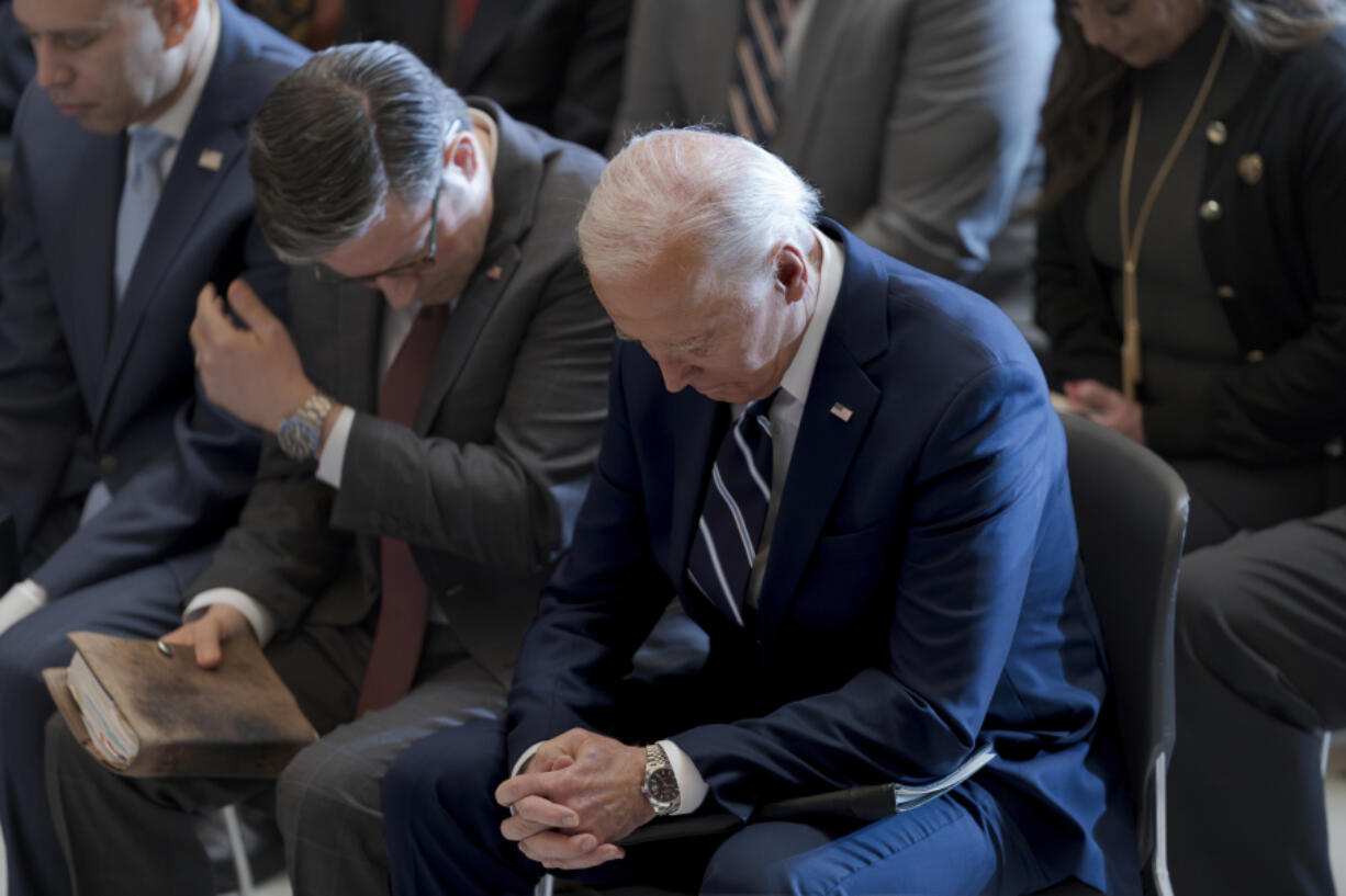 President Joe Biden, with from left, House Minority Leader Hakeem Jeffries, D-N.Y., and House Speaker Mike Johnson of La., pray and listen Feb. 1 during the National Prayer Breakfast at the Capitol in Washington. Johnson has spoken in the past of his belief America was founded as a Christian nation. Biden, while citing his own Catholic faith, has spoken of values shared by people of &ldquo;any other faith, or no faith at all.&rdquo; (J.