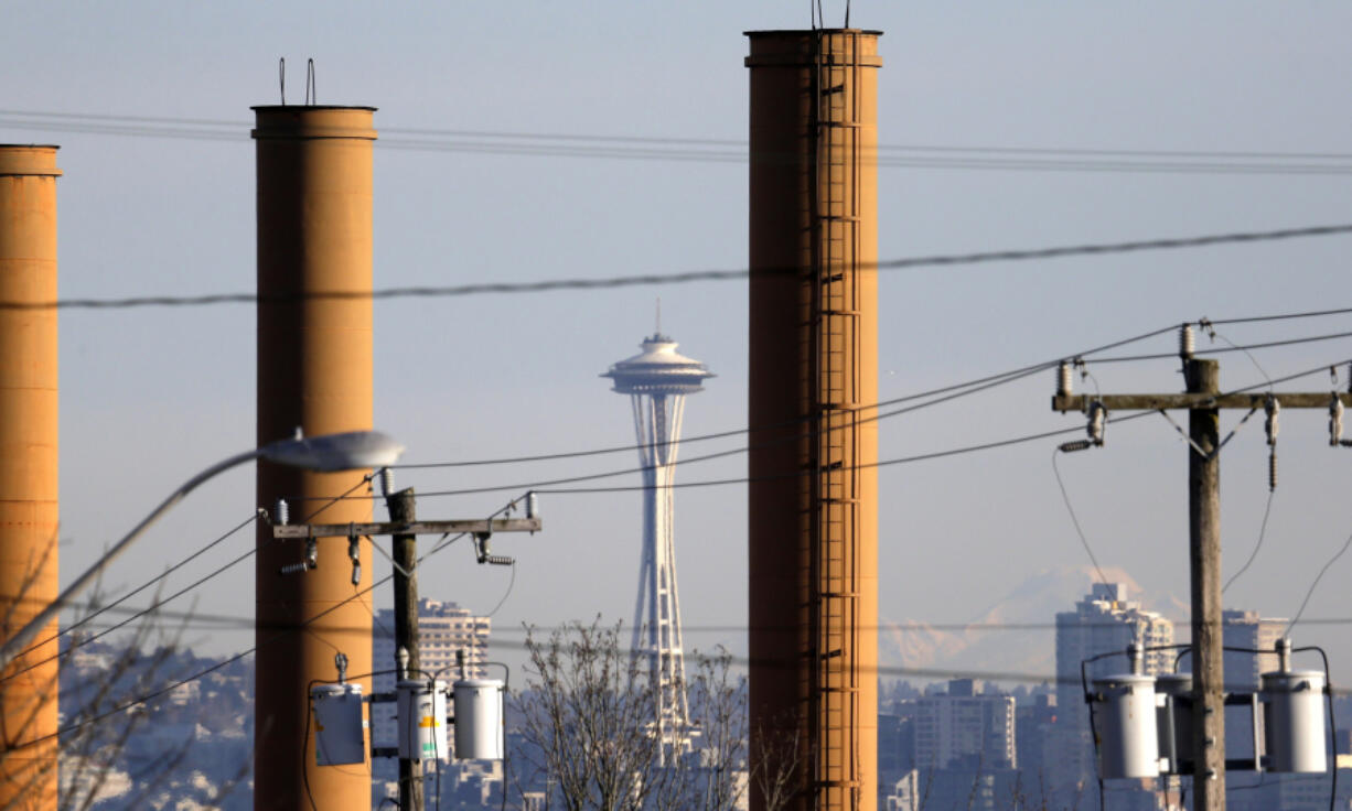 FILE - The Space Needle is seen in view of still-standing but now defunct stacks at a steel plant in Seattle on Feb. 25, 2016. A conservative-backed effort to repeal Washington state&#039;s landmark carbon pricing program and tax on the sale of stocks and bonds is putting the budget into limbo, with billions of dollars at stake and just days left in this year&#039;s Legislative session.