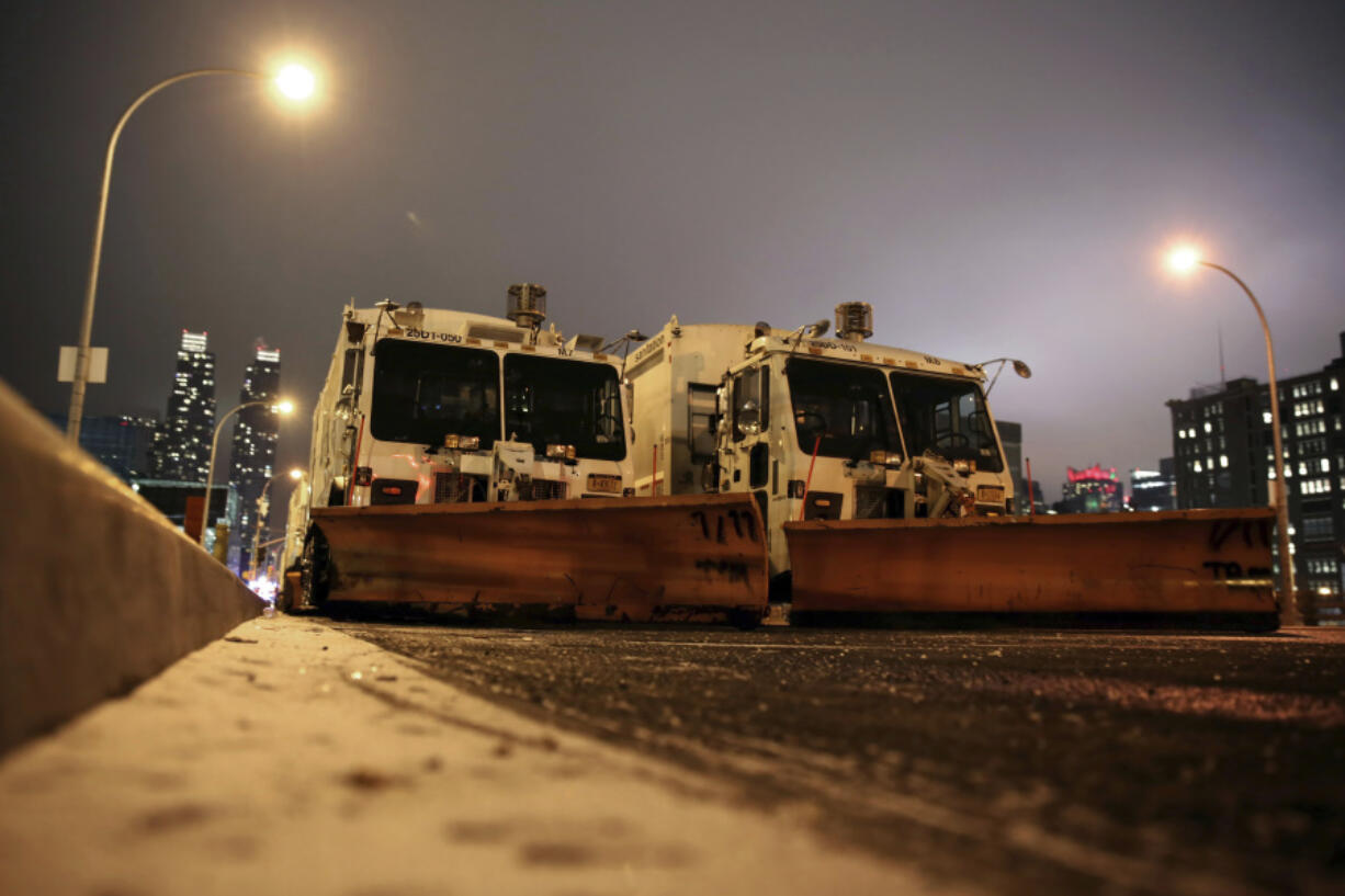 FILE &mdash; Sanitation trucks mounted with snow plows are parked on the west side of Manhattan in New York, Jan. 2, 2014. Parts of the Northeast were preparing Monday, Feb.