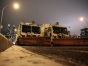 FILE &mdash; Sanitation trucks mounted with snow plows are parked on the west side of Manhattan in New York, Jan. 2, 2014. Parts of the Northeast were preparing Monday, Feb.