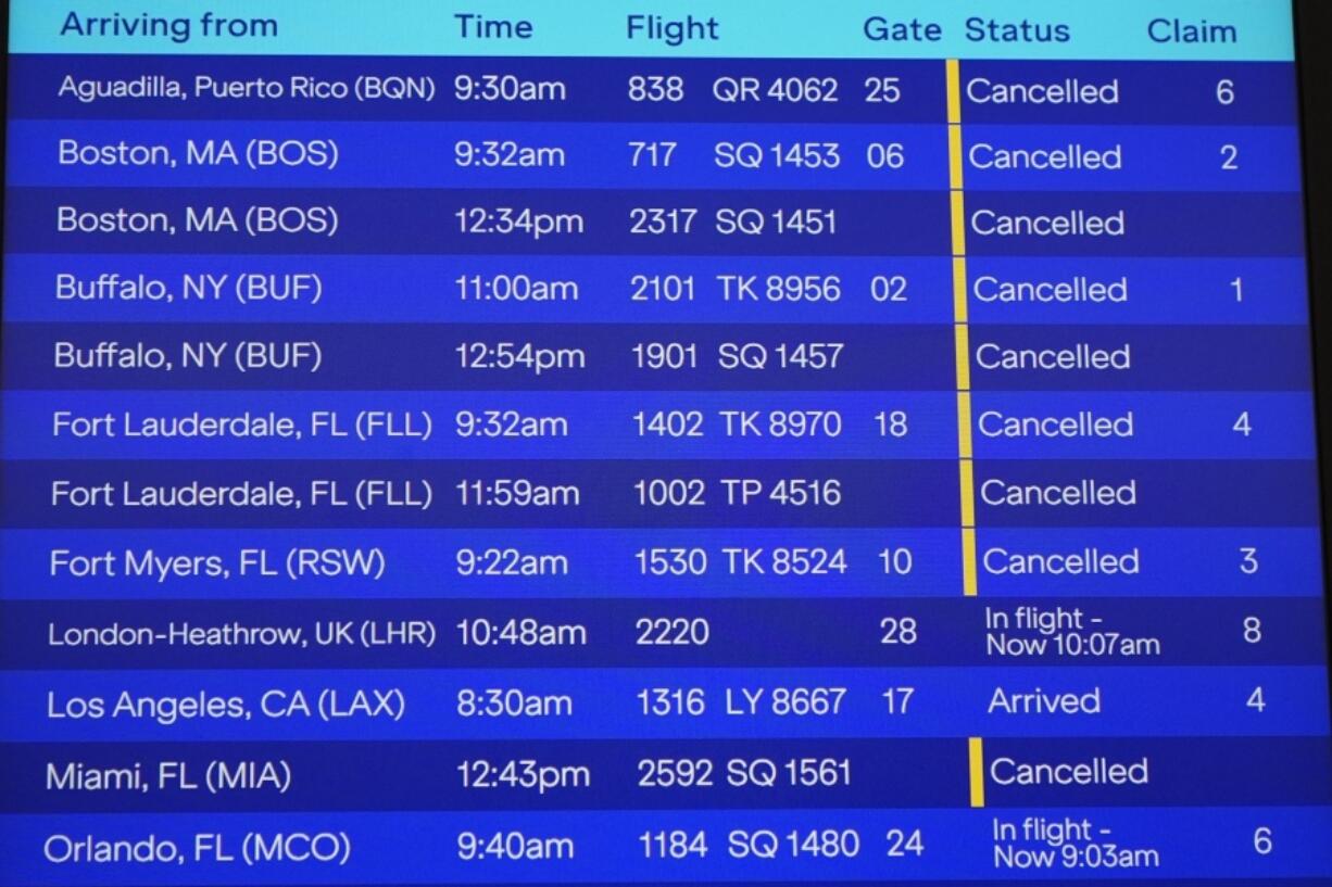 Flight cancellations are listed due to inclement weather are shown on an information board at John F. Kennedy International Airport Tuesday, Feb. 13, 2024, in New York. Parts of the Northeast were hit Tuesday by a snowstorm that canceled flights and schools and prompted warnings for people to stay off the roads, while some areas that anticipated heavy snow were getting less than that as the weather pattern changed.