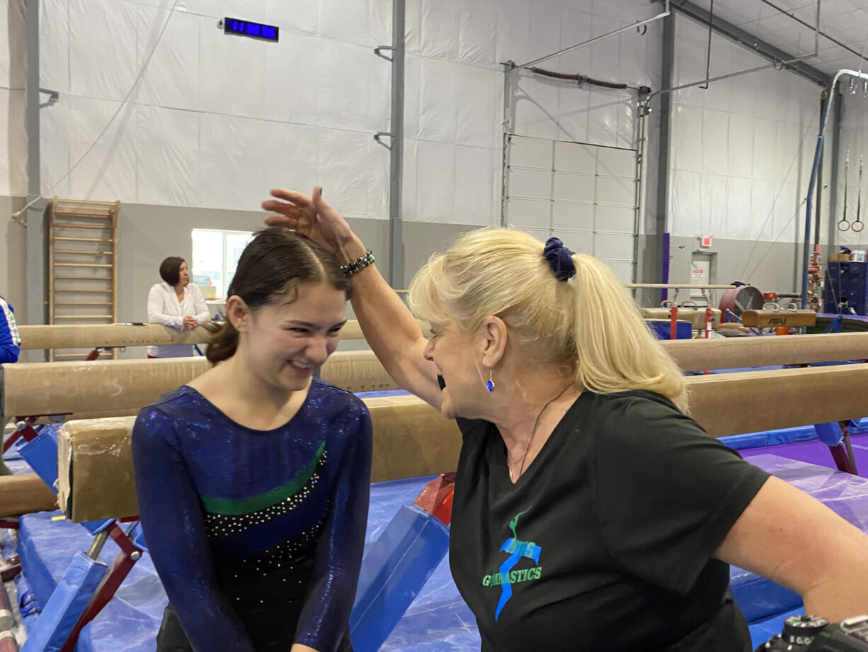 Mountain View coach Cristi Westcott (right) congratulates Analise Jaso after her bars routine during Saturday's 3A/2A district gymnastics meet at Naydenov Gymnastics. Westcott is retiring after 40 years as Mountain View's coach.