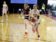 Columbia River's Emma Iniguez (20) dribbles the ball ahead of Archbishop Murphy's Taylor Cushing in a Class 2A girls basketball consolation game on Friday, March 1, 2024 in Yakima.