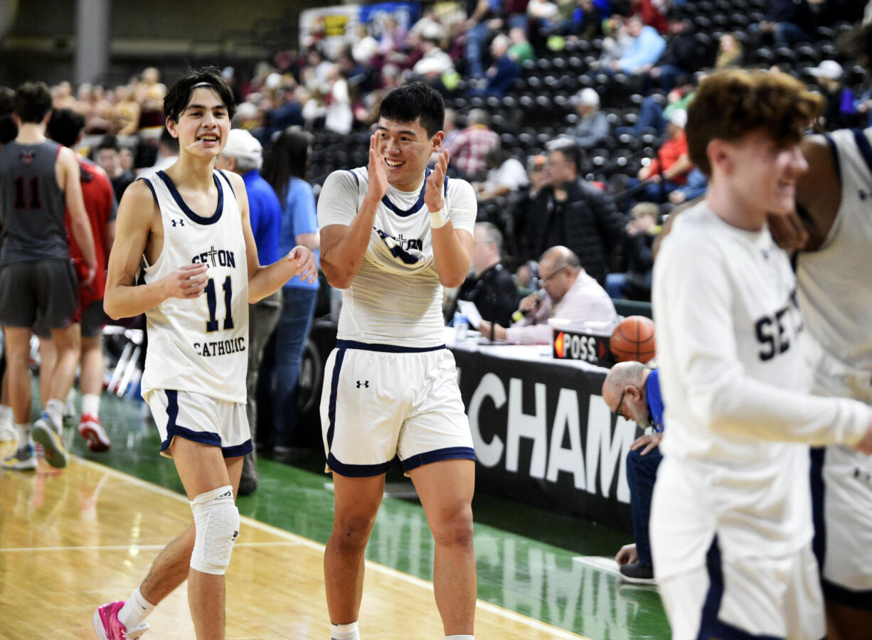 Seton Catholic's Rico George, left, and Lance Lee celebrate after a 49-40 win over Riverside in a Class 1A boys basketball consolation round game on Friday, March 1, 2024 in Yakima.