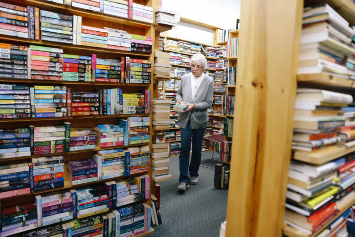 Karen Kropp locates books for a customer at The Book Rack, a bookstore she has owned for nearly two decades, on Feb. 14, 2024, in Arcadia, California. At the end of the month, she is closing the bookstore doors and moving to Albuquerque with family.