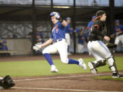 Ridgefield&#039;s Jared Gottsch (7) slides into home plate to score the Spudders&#039; first run of a season-opening, non-league baseball game against Battle Ground on Friday, March 8, 2024, at Ridgefield Outdoor Recreation Complex.