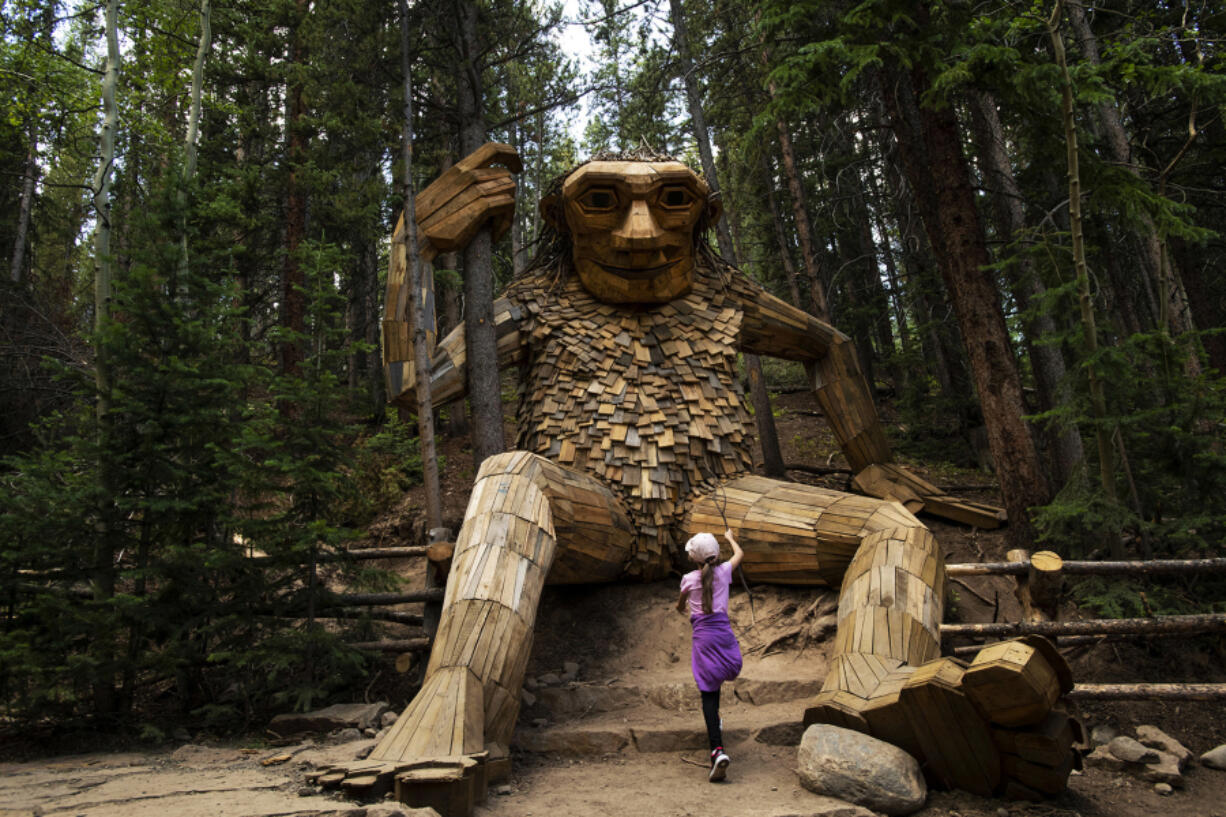 Josie Bozarth, checks out Isak Heartstone, a 15-foot tall wooden troll sculpture by Danish artist Thomas Dambo, in Breckenridge, Colorado, on Saturday, Aug. 4, 2019.
