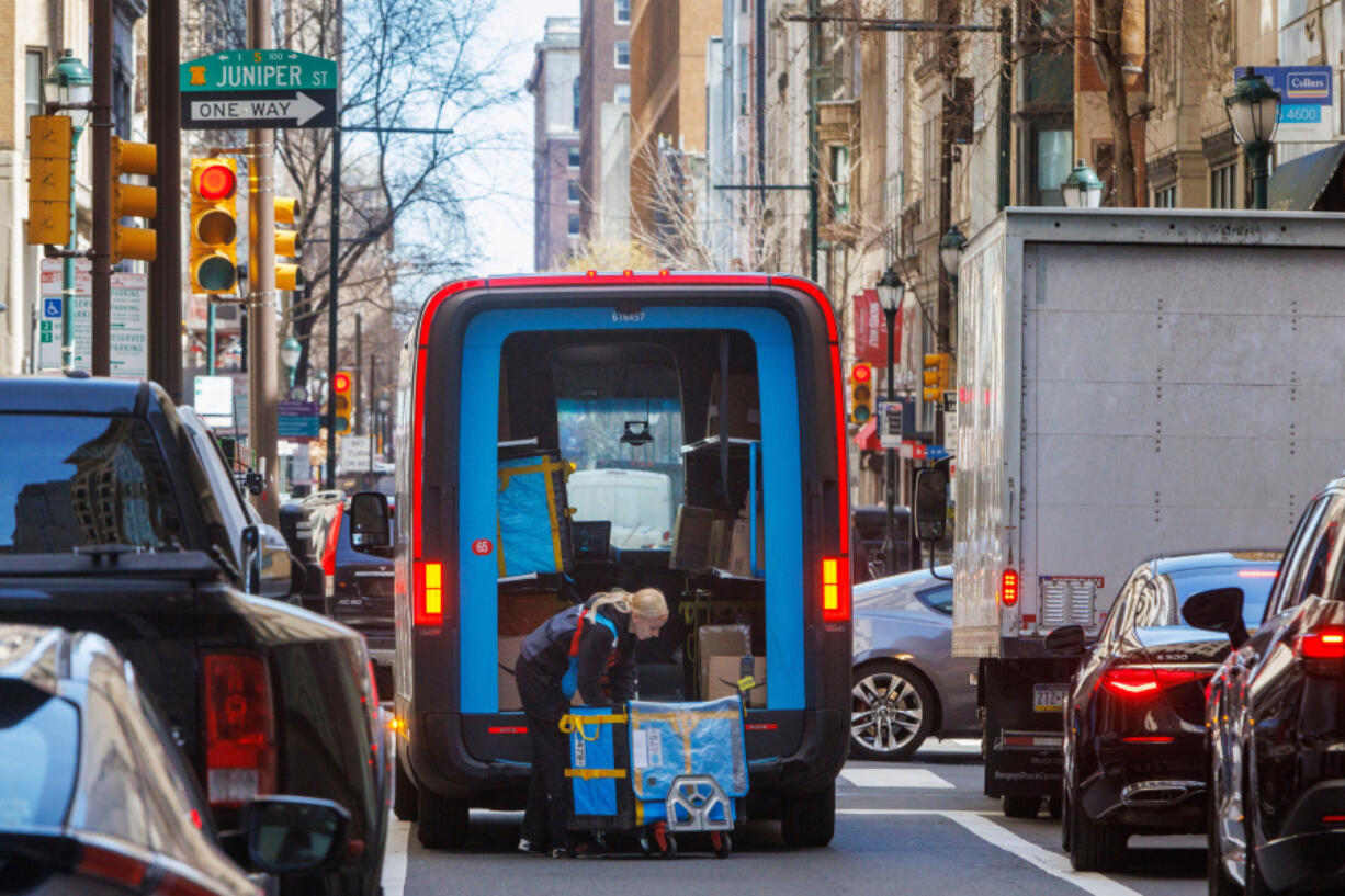 An Amazon delivery person takes packages out of her truck on Chestnut Street in Center City. Some Philadelphia consumers say they can&rsquo;t break their Amazon shopping habit, despite having ethical concerns with the company and its owner, billionaire Jeff Bezos. (Alejandro A.