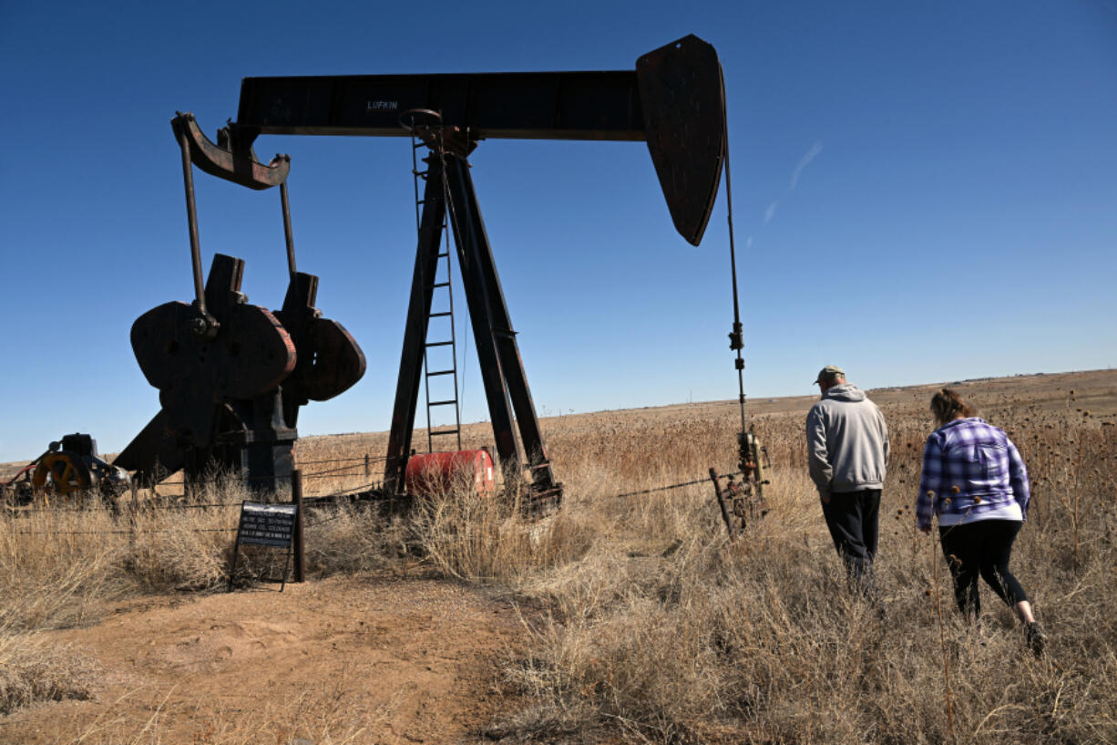 Homeowners Ron and Cindy McCormick walk near a pump jack and other abandoned oil and gas equipment on their land in Hudson, Colorado, on Feb. 28, 2024. (Helen H.