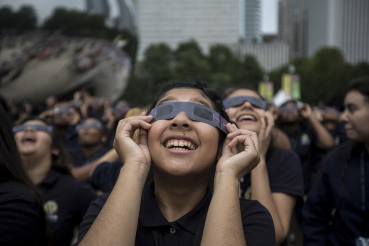 Students from Muchin College Prep react as the solar eclipse emerges from behind clouds in Millennium Park in Chicago on Aug. 21, 2017.