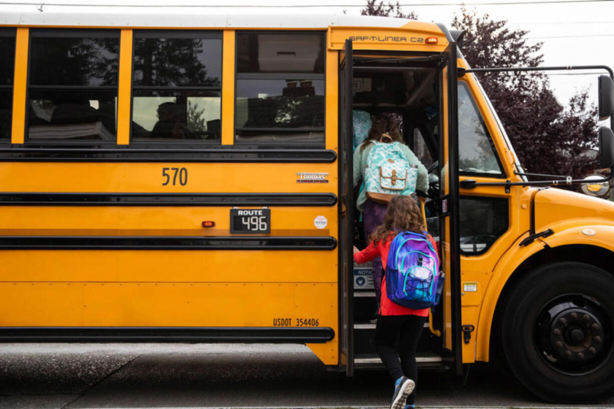 Students board the bus to Hamilton International Middle School on the first day of school in this Sept. 14, 2022 file photo. A proposal to transition Washington&Ccedil;&fnof;&Ugrave;s diesel-powered school buses to zero-emission alternatives has passed the Legislature.