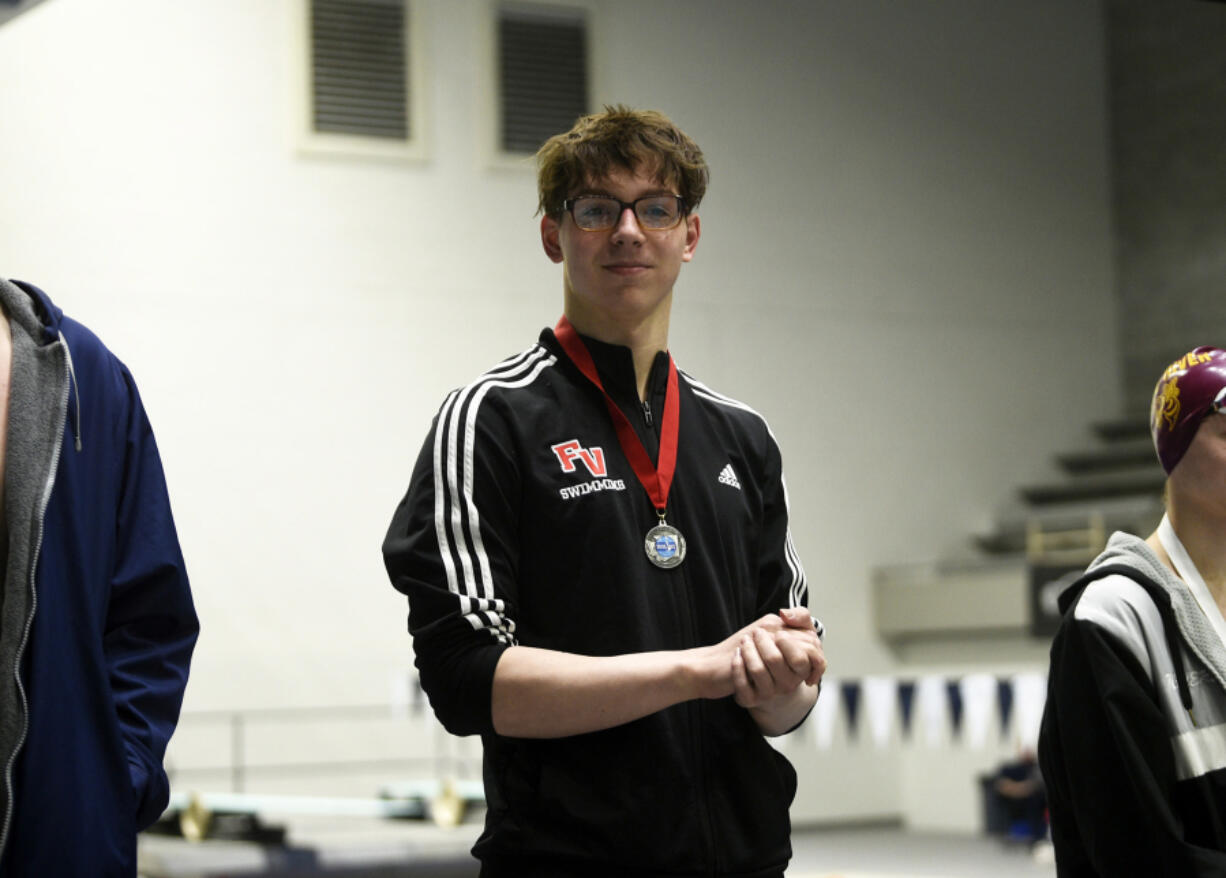 Tarik Kurta of Fort Vancouver stands on the podium after finishing second in the 50 freestyle at the 2A boys swimming state championship meet at the King County Aquatic Center in Federal Way on Saturday, Feb. 17, 2024.