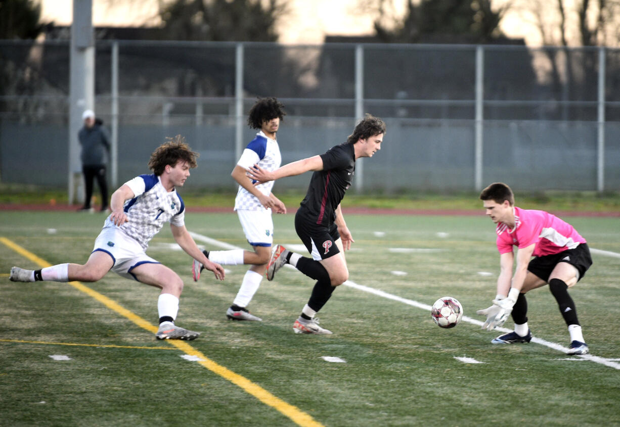 Mountain View goalkeeper Owen Purvis, right, reaches out to grab a loose ball in front of Prairie's Luke Cochran, center, during a 3A Greater St. Helens League boys soccer game on Friday, March 15, 2024, at Prairie High School.