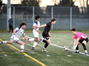 Mountain View goalkeeper Owen Purvis, right, reaches out to grab a loose ball in front of Prairie's Luke Cochran, center, during a 3A Greater St. Helens League boys soccer game on Friday, March 15, 2024, at Prairie High School.