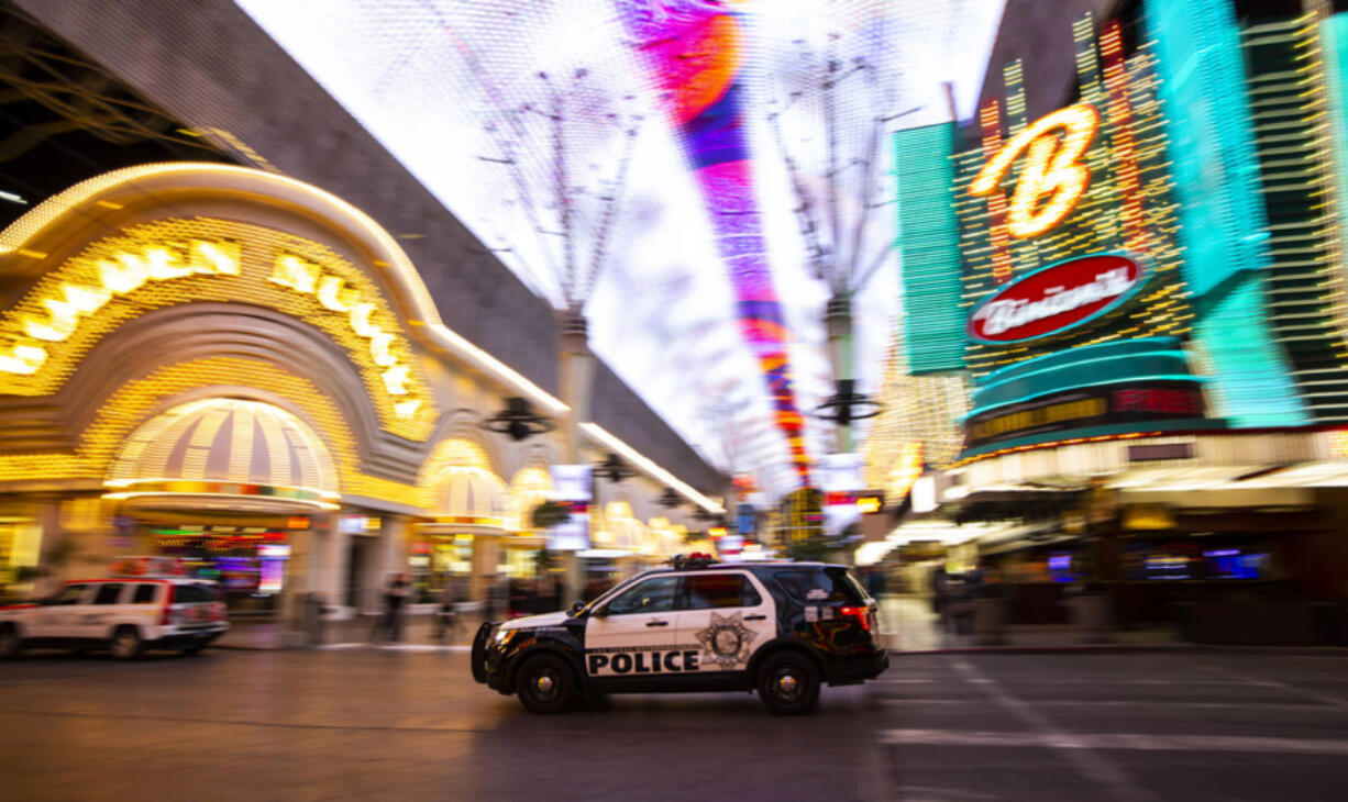 A Las Vegas police vehicle passes the Fremont Street Experience following Nevada Gov. Steve Sisolak&rsquo;s statewide order that nonessential businesses shut down for the next 30 days in Las Vegas on Tuesday, March 17, 2020.