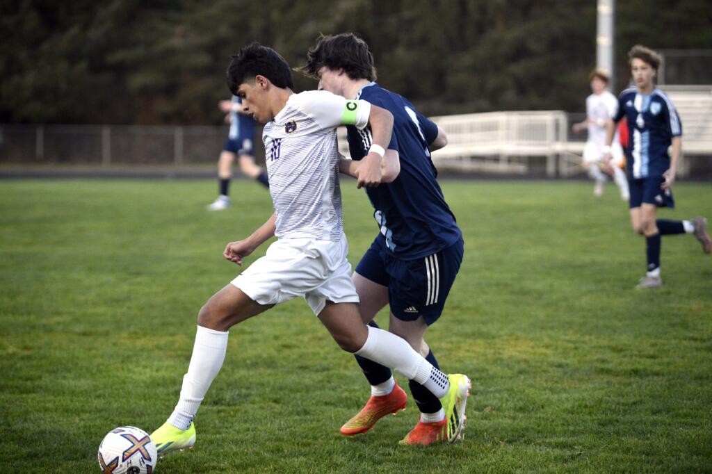 Columbia River's JP Guzman dribbles up the field while being tracked by Hockinson's Kirby VanderHouwen during a 2A GSHL boys soccer match on Tuesday, March 19, 2024, at Hockinson High School.