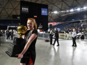 Camas senior Addison Harris smiles as she leaves the floor of the Tacoma Dome with the state championship trophy  after the Papermakers&rsquo; 57-41 win against Gonzaga Prep.