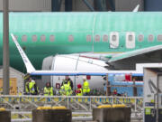 Workers are pictured next to an unpainted 737 aircraft and unattached wing with the Ryanair logo as Boeing&rsquo;s 737 factory teams hold the first day of a &ldquo;Quality Stand Down&rdquo; for the 737 program at Boeing&rsquo;s factory in Renton, Washington on Jan. 25, 2024.