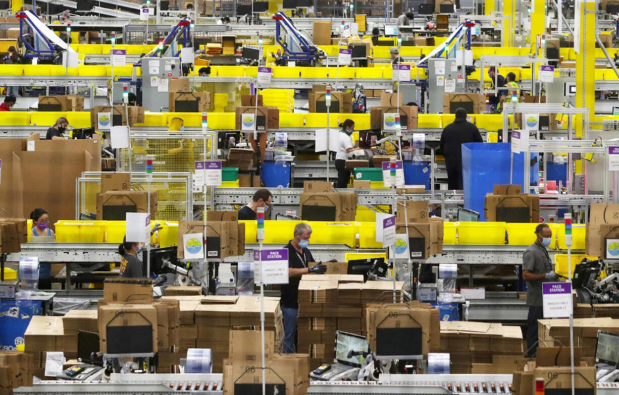 Employees at packing stations are seen at Amazon&rsquo;s Kent, Washington, fulfillment center on June 11, 2020. Amazon says 2023 data points to a year of &ldquo;meaningful, measurable progress&rdquo; but two advocacy groups say the company&rsquo;s numbers don&rsquo;t tell the full story.