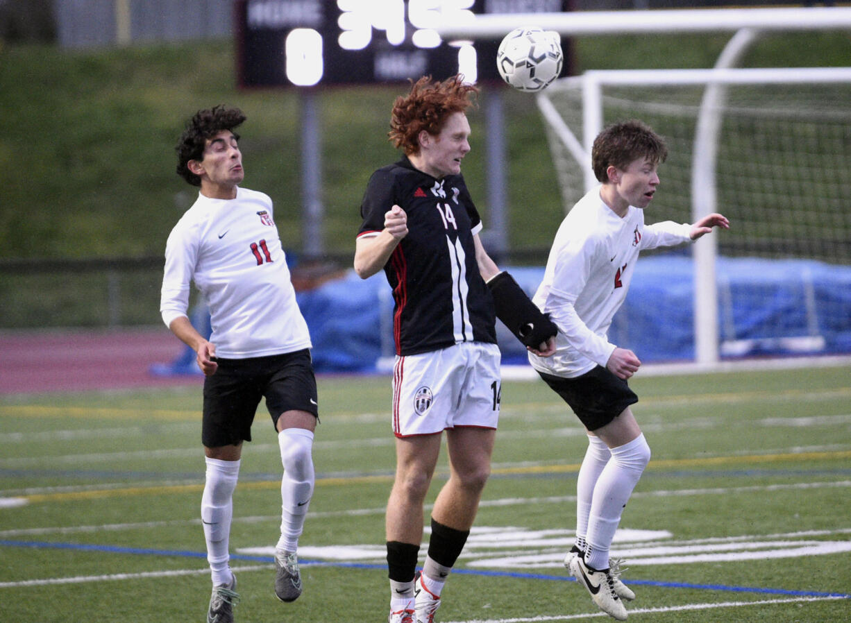 Union's Caleb Putney, center, goes up for a header between Camas' Shiven Friedeman, left, and Travis O'Hara during a 4A Greater St. Helens League boys soccer match on Thursday, March 28, 2024, at Union High School.
